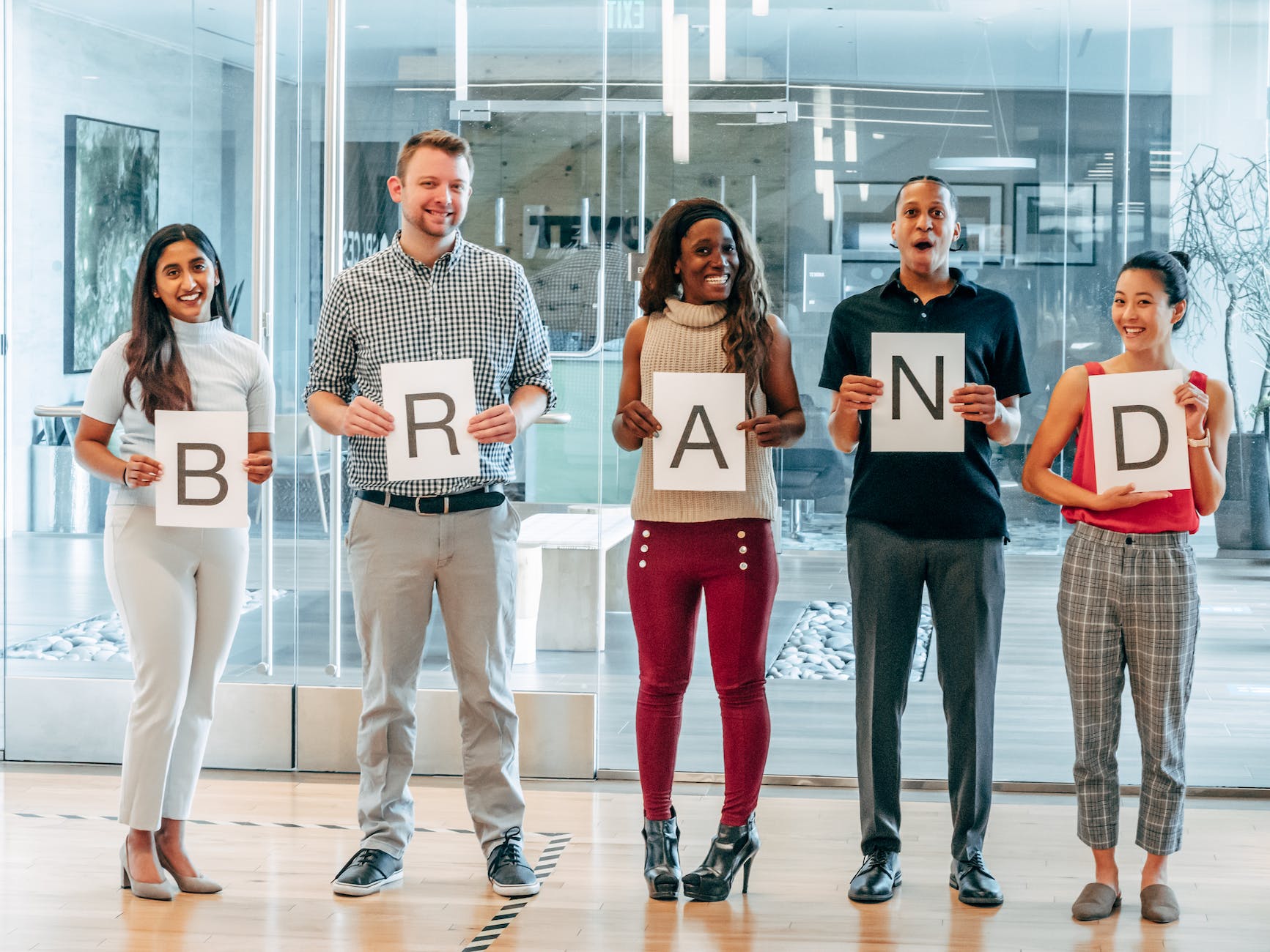 happy coworkers holding up letters on pieces of paper